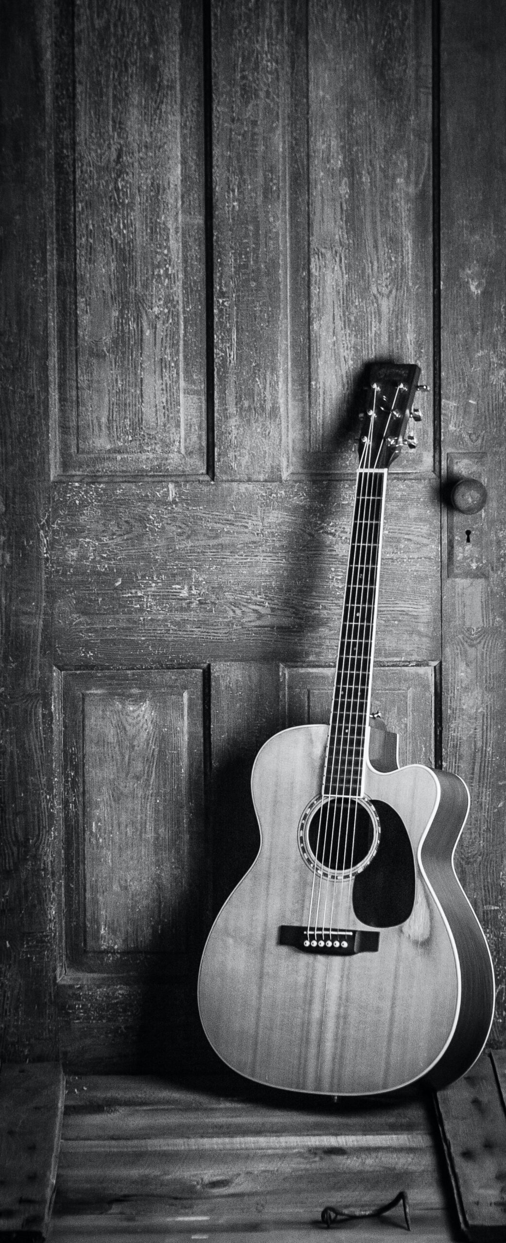 Guitar leaning against door picture in black & white